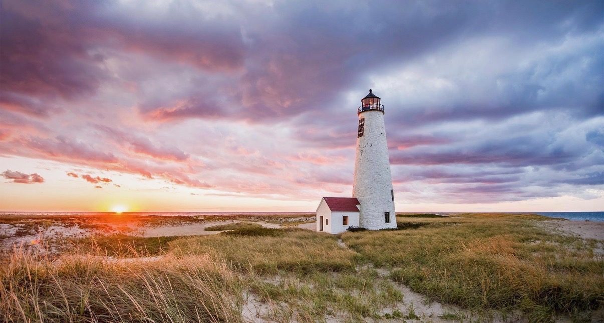 Great Point Lighthouse at sunset, beach grass in the foreground.