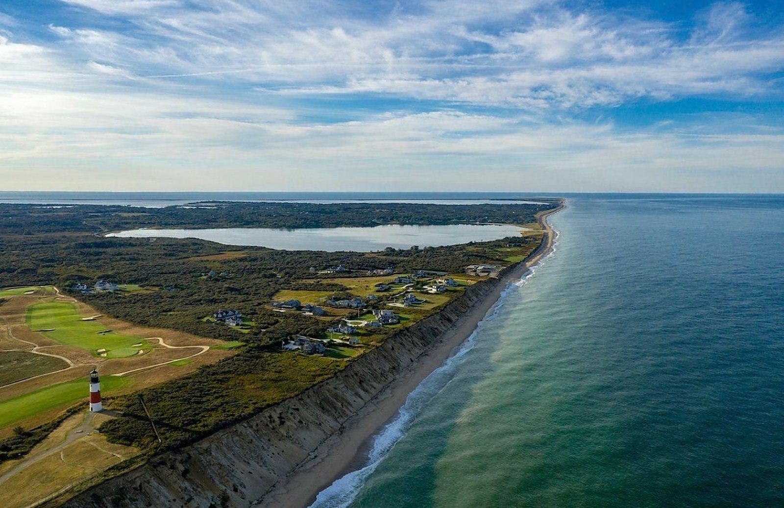 The Sankaty Head coastline from the air &mdash; the red-banded lighthouse above the bluff, the moors and the Atlantic.